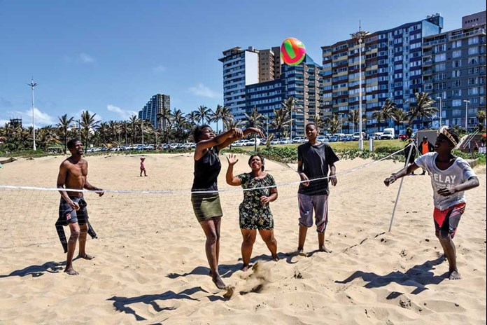 Young people from Umthombo’s post-16 programme playing volley ball on the beach.