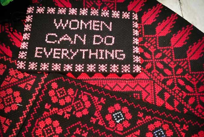 A piece of red and black crochet that reads. "Women can do everything."