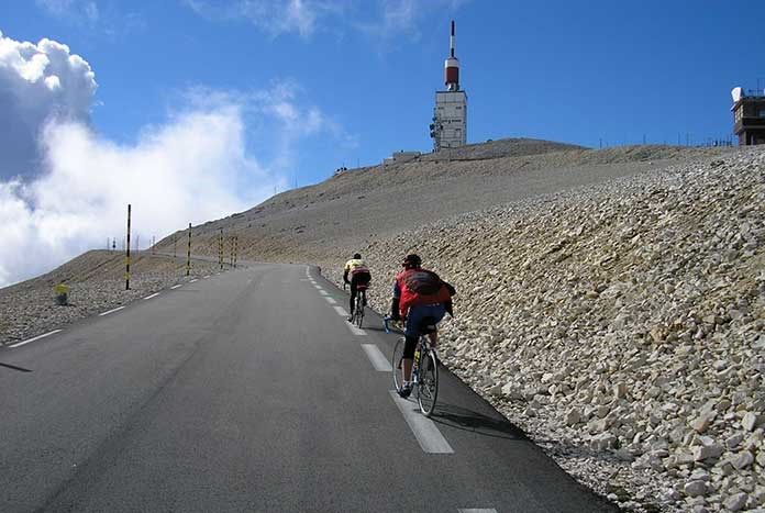 Two cyclists reaching the summit of Mount Ventoux.
