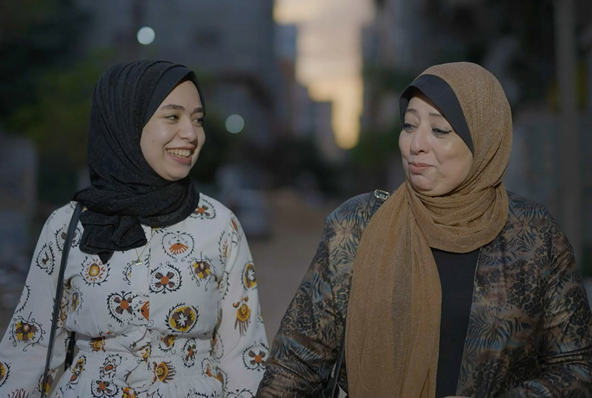 A Gazan mother and daughter walking and smiling together