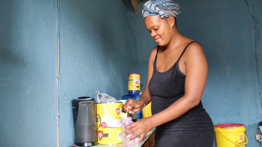 A young woman from uMthombo's Independent Living Programme in Durban, South Africa prepares food for her baby.