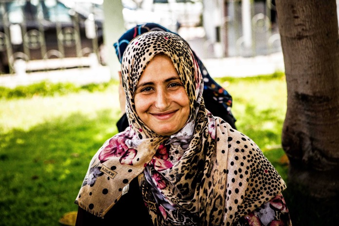 A women sits smiling outside Al Ahli Arab Hospital in Gaza City.