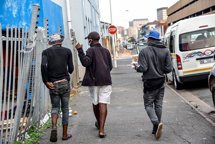 Three South African men walking down a street in Durban.