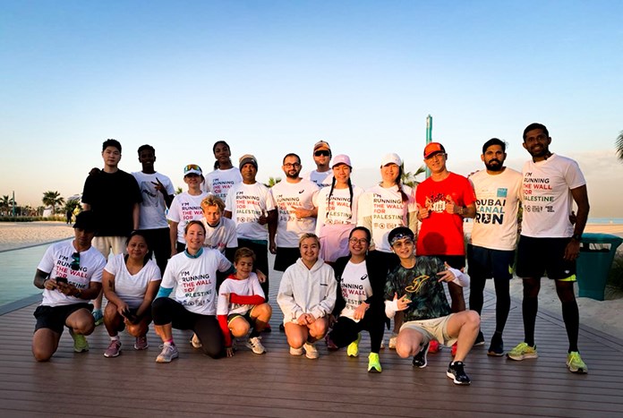 A group of runner in Dubai at sunset wearing Run The Wall for Palestine T-shirts.