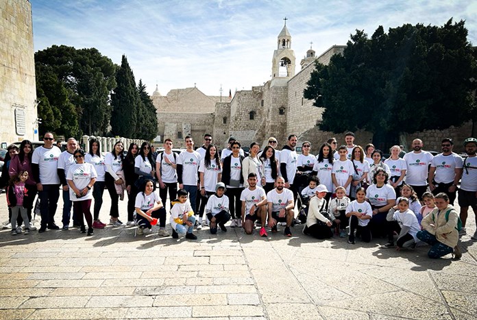 A group of runners in Manger Square in Bethlehem wearing Run The Wall T-shirts.