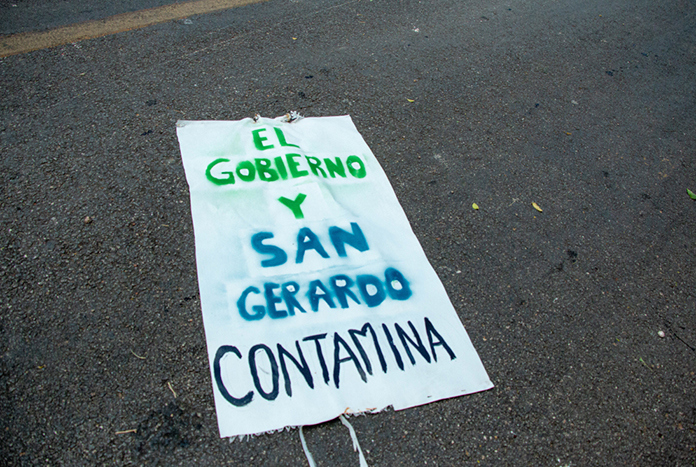A sign on the ground reads, "El Gobiero Y San Gerardo Contamina"
