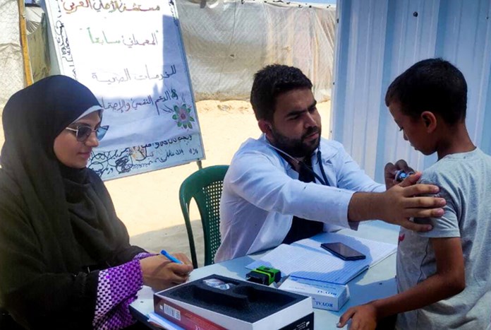 Doctors from Al Ahli Baptist Hospital in Gaza City check a young boy in a make-shift field hospital.